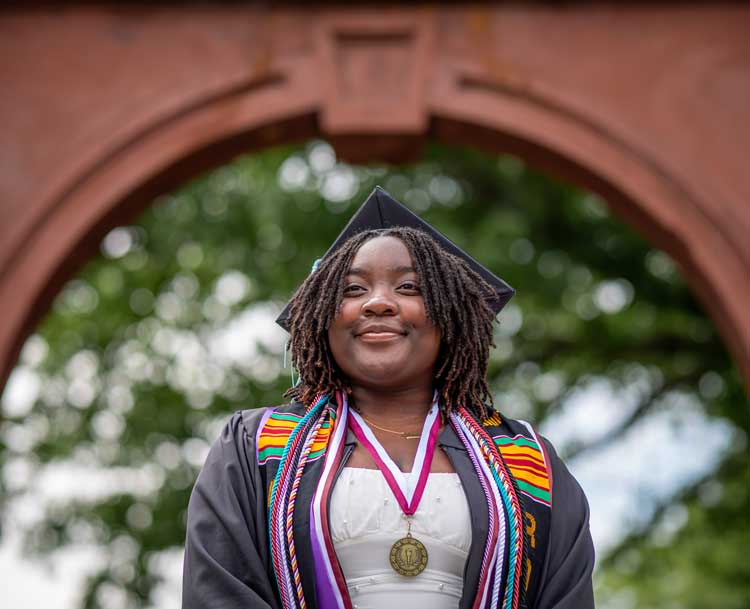 student in a graduation cap and gown smiling